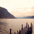 Small pier and calm water. Cloudy day on Como lake Royalty Free Stock Photo