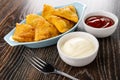 Small pies samsa in oval plate, bowls with ketchup and mayonnaise, fork on wooden table Royalty Free Stock Photo