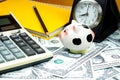 Small piggy bank and financial calculator on Piles of US dollar Royalty Free Stock Photo