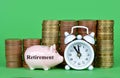 The small piggy bank with pile of coins and white retro alarm clock on green background. Royalty Free Stock Photo