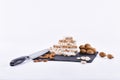 Small pile of almond nougat chunks surrounded by assorted almonds and a kitchen knife Royalty Free Stock Photo