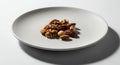 A small pile of mixed nuts sits on a white plate Royalty Free Stock Photo