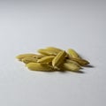 A small pile of unprocessed rice grains (Oryza sativa) is placed on a smooth, light Royalty Free Stock Photo