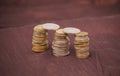 Small pillars of golden and silver coins kept diagonally on a brown background.