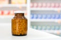 Small pills in transparent amber medicine bottle