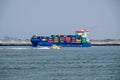 Small pilot boat passes sea going container ship