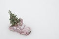 Small pink toy car with a fir tree on a snowy road. Festive Christmas card Royalty Free Stock Photo