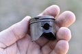 A small piston in the hand from an internal combustion engine