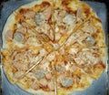 Delicious and fresh pizza on the table. Small pizza with sliced meatballs, sausage and grated cheese. Top View Royalty Free Stock Photo