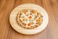 Small pizza with whole roasted cherry tomatoes, mushroom slices and lots of melted cheese with oregano Royalty Free Stock Photo