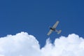 Small plane flying against blue sky and clouds Royalty Free Stock Photo