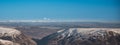 Small plane flying over mountains in Perthshire, Scotland. Summits of Cairngorms National Park covered in snow in the background Royalty Free Stock Photo