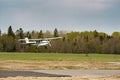 Small plane stands on the runway against the background of the forest Royalty Free Stock Photo
