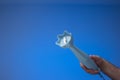 Small plastic hand food blender held in hand by male hand. Close up studio shot, isolated on blue background