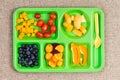 Small plastic lunch tray with fruit and spoon
