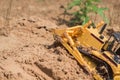 Small plastic toy digger working on sand quarry, construction concept Royalty Free Stock Photo