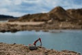 Small plastic toy excavator with bucket working on sand extraction at quarry. Pond in background. Children`s toy model of tractor Royalty Free Stock Photo