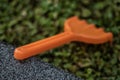 Small plastic toy rake resting on the grass Royalty Free Stock Photo