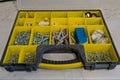 Small plastic yellow boxes with different screws and fasteners. Selective focus Royalty Free Stock Photo