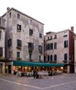 A restaurant on a small plaza with building in Venice Italy
