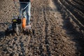 Small plowing machine in hands of a farmer making arable in black soil