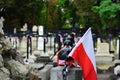 Small Polish flag on the old cemetery. National memory day concept.