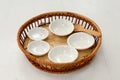 Small porcelain cups in bamboo basket on white background
