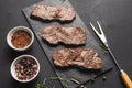 Small pork steaks on black background