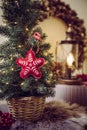 Small portable tabletop decorated Christmas tree on table  party lights illuminated  red felt fabric ornament. Royalty Free Stock Photo