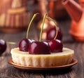 Small portion cheesecake with fresh sweet cherries against of cooper dish