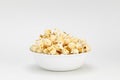 Small portion of popcorn in a white bowl with a white background