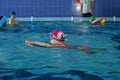 Small preschooler child learns to swim with board in pool. Swimming lesson
