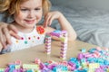 Small preschooler girl playing with colorful toy building blocks, sitting at the table Royalty Free Stock Photo