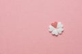 Small Pretty Flower Made of Heart Shape Sugar Candy White and Red Sprinkles on Pastel Pink Background. Valentines Mother`s Day