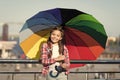 Small pretty girl standing with colorful umbrella. Girl on bridge. Hiding from sun with umbrella. Bright shades of girl Royalty Free Stock Photo