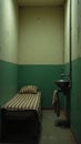 Small Prison Cell With Narrow Bed and Simple Amenities Royalty Free Stock Photo