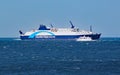 A small private motor boat crosses by an Interislander ferry on the Cook Strait Royalty Free Stock Photo