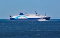 A small private motor boat crosses by an Interislander ferry on the Cook Strait