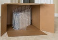 Small product wrapped in plastic wrap inside very large cardboard shipping box Royalty Free Stock Photo