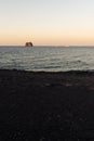 The small promontory of Strombolicchio from Stromboli`s black beach at sunset in Sicily, Italy