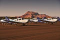 Small propeller airplanes parked on an airfield during sunset with mountains in the background. Oxford Aviation Academy flight