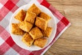 Small puff cookies in plate on napkin on wooden table. Top view