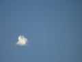 A small puffy white cloud in blue sky Royalty Free Stock Photo