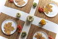 small pumpkins and dry brown maple leafs on white plates, autumn dinner table