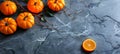 Small pumpkins and an orange slice on a dark marble surface. Fresh autumn harvest. Concept of fall, seasonal produce Royalty Free Stock Photo