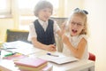 Small pupils, boy and girl, sitting at his desk.