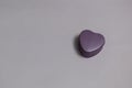 Small purple heart-shaped box with a light shadow on a light pink background Royalty Free Stock Photo