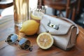 small purse with a lemon and sunglasses on caf table