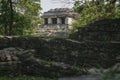 Small pyramid Mayan temple behind ruin walls at the archaeological site of Palenque, Chiapas, Mexico Royalty Free Stock Photo