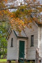 Small quaint disused rural white weatherboard church front entrance surrounded by autumnal trees Royalty Free Stock Photo
